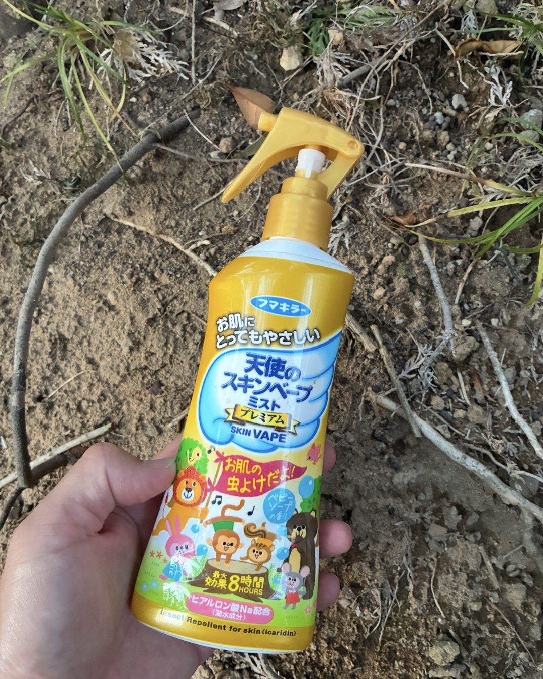 天使のスキンベープミスト プレミアムの本体を山の中で手に持っているところ