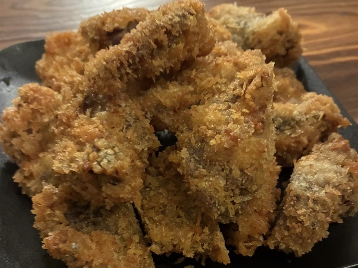 揚がった鹿カツを黒い皿に盛ったところ