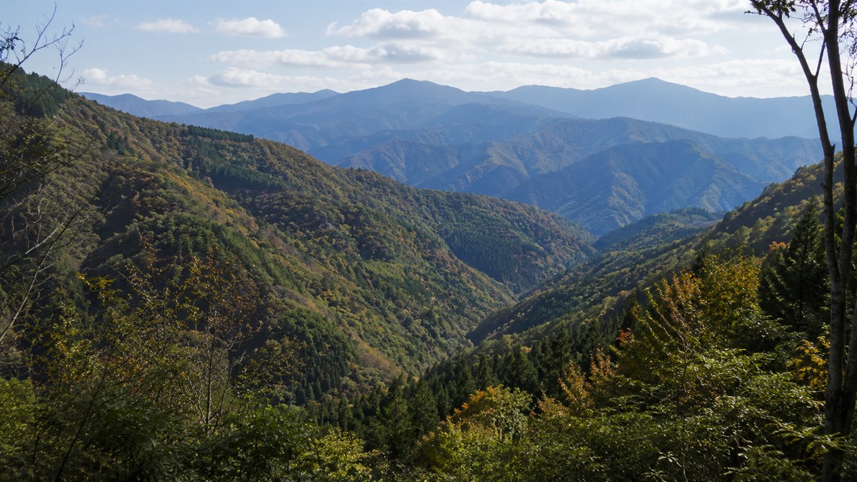 秋の山なみ。谷筋の向こうに稜線が重なって見える